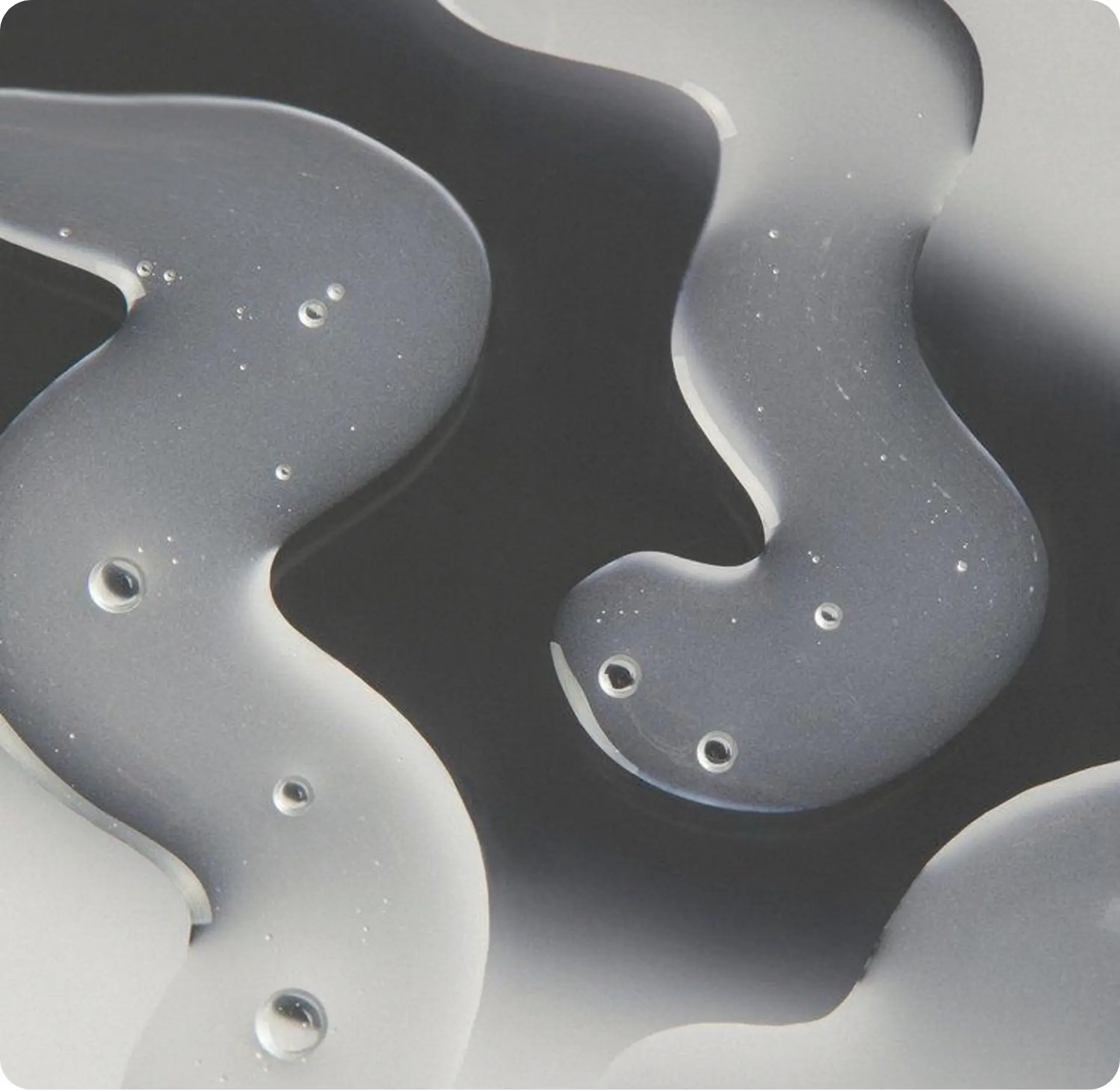 Grey and off-white liquid swirls photographed in close-up